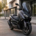 Czarny skuter z wysoką szybą zaparkowany przy nowoczesnym budynku o zmierzchu