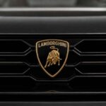 Złoty emblemat Lamborghini na czarnym grillu samochodu