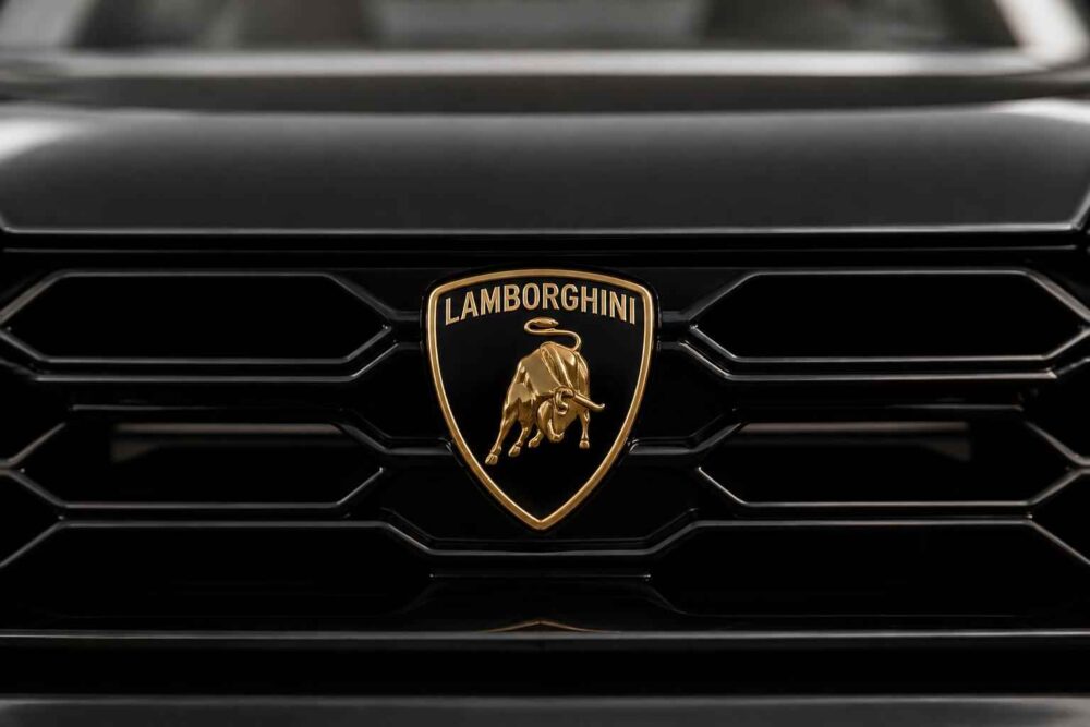 Złoty emblemat Lamborghini na czarnym grillu samochodu